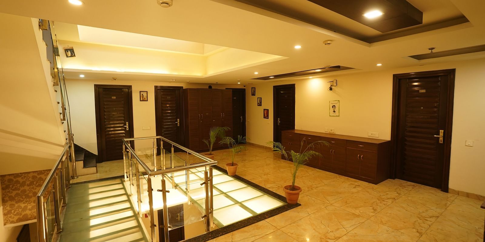 The interior of Hotel Dreamland Chandigarh, featuring the lobby area with a staircase, a reception desk, and several doorways.