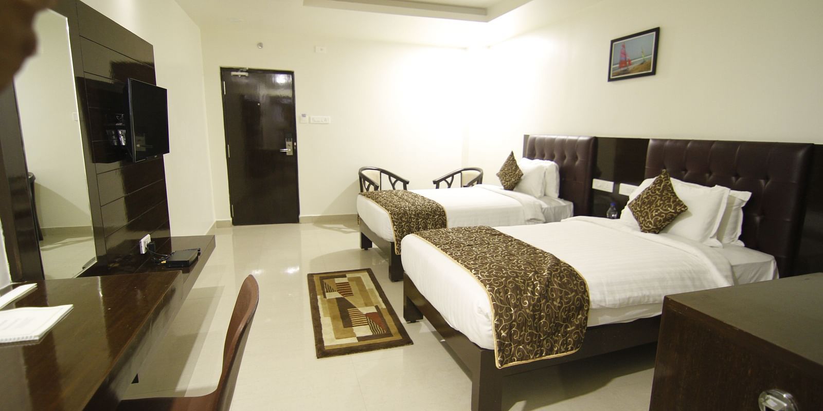 Suite with twin beds and a television in front of it at Hotel Green Apple