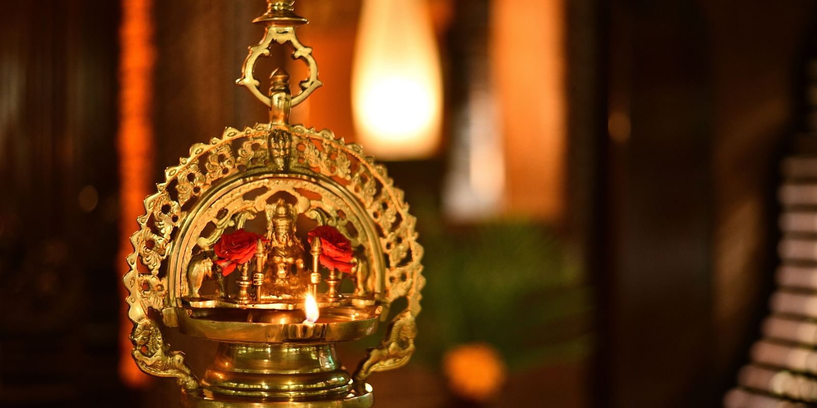 a bronze oil lamp with a goddess figure ingrained at Hoysala Village Resort, Hassan