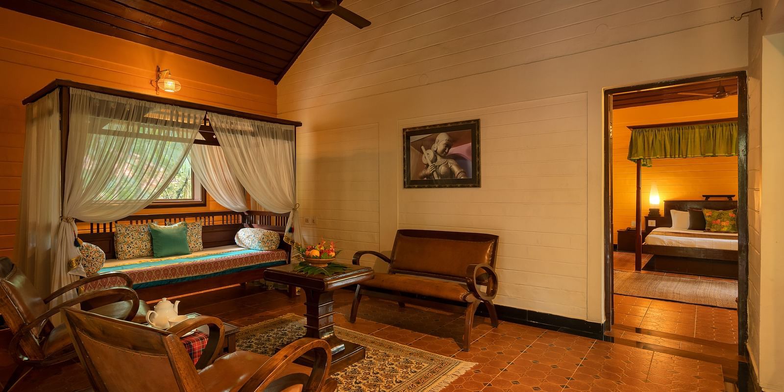 An image of a seating room which also gives a sneak peak of a bedroom - Hoysala Village Resort, Hassan