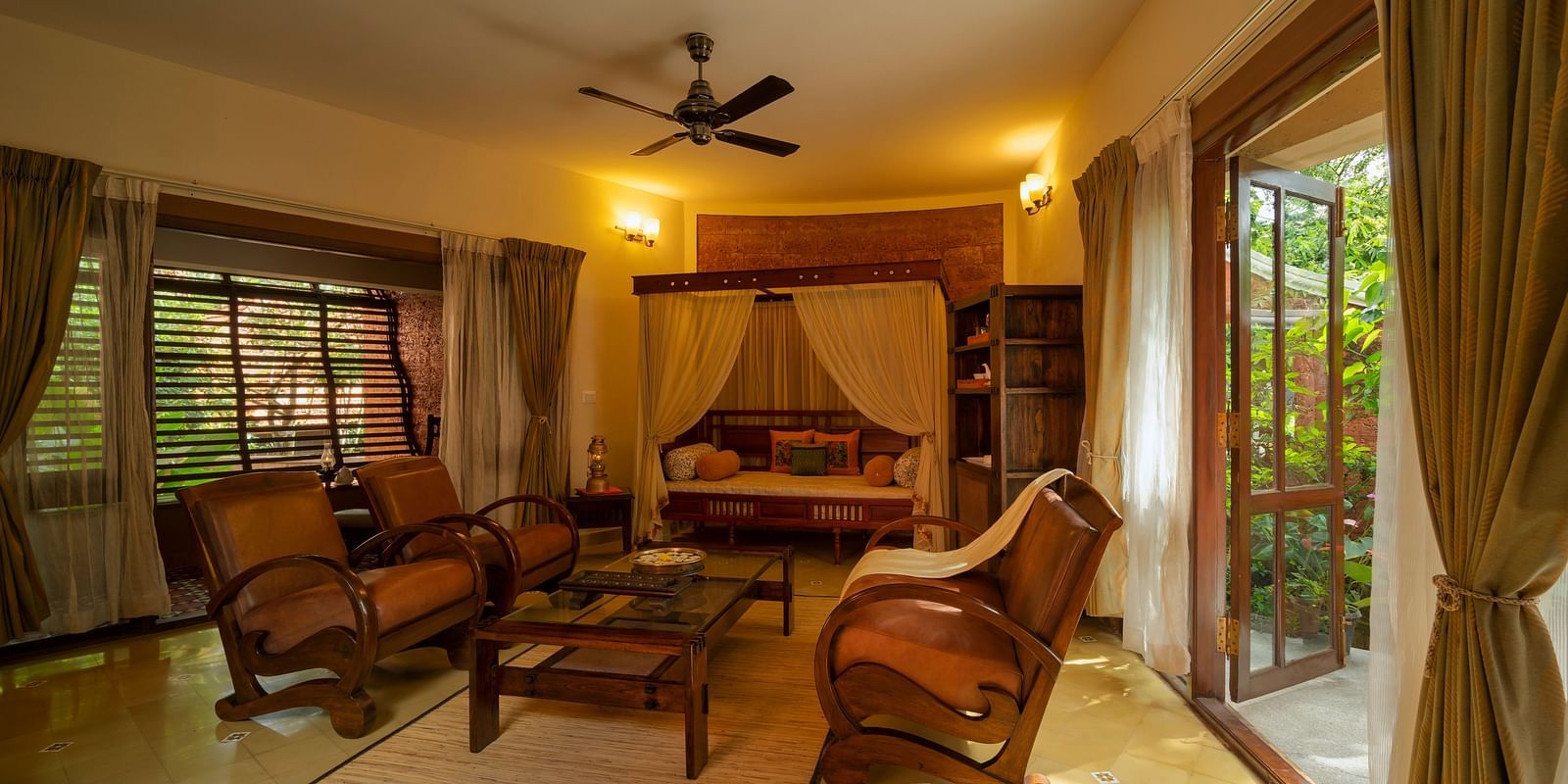 An overview of the living area with sofas and coffee table inside luxury jacuzzi villa at hoysala village resort in hassan