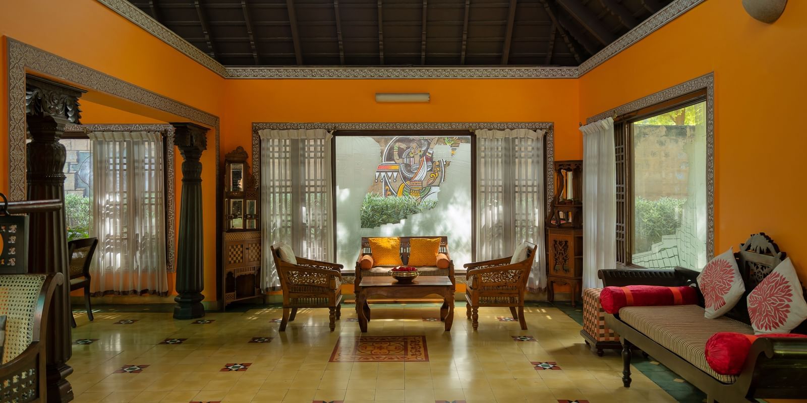 An overview of the lobby of Hoysala Village Resort, Hassan, with seating arrangements in view.