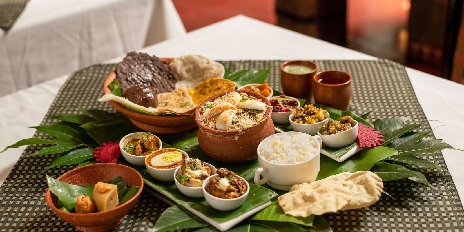 image of a full platter of food served on plantain leaves at Hoysala Village Resort, Hassan