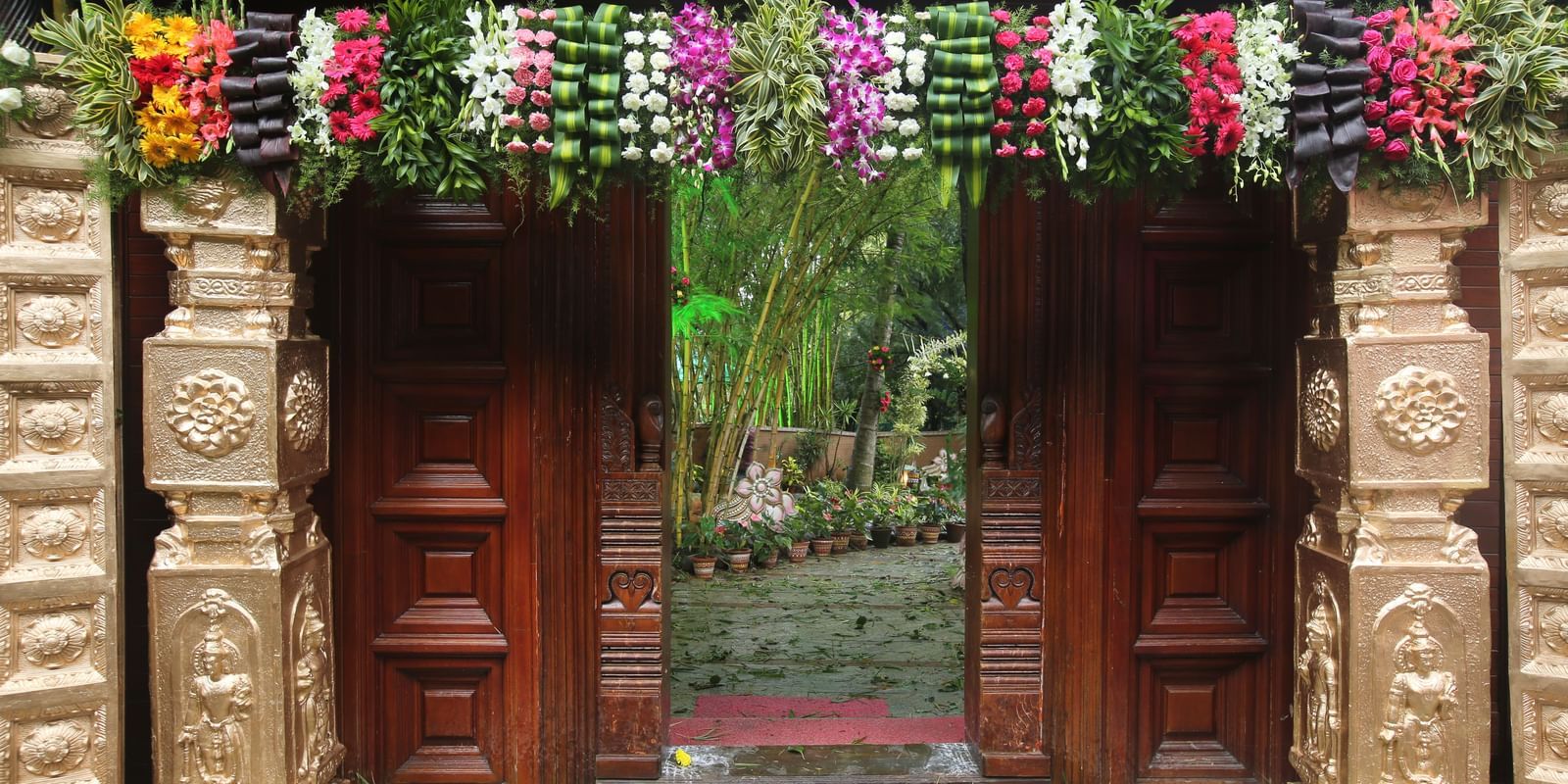 image of an entrence at hoysala village resort decorated with pillars and flowers in a very beautiful manner for a wedding