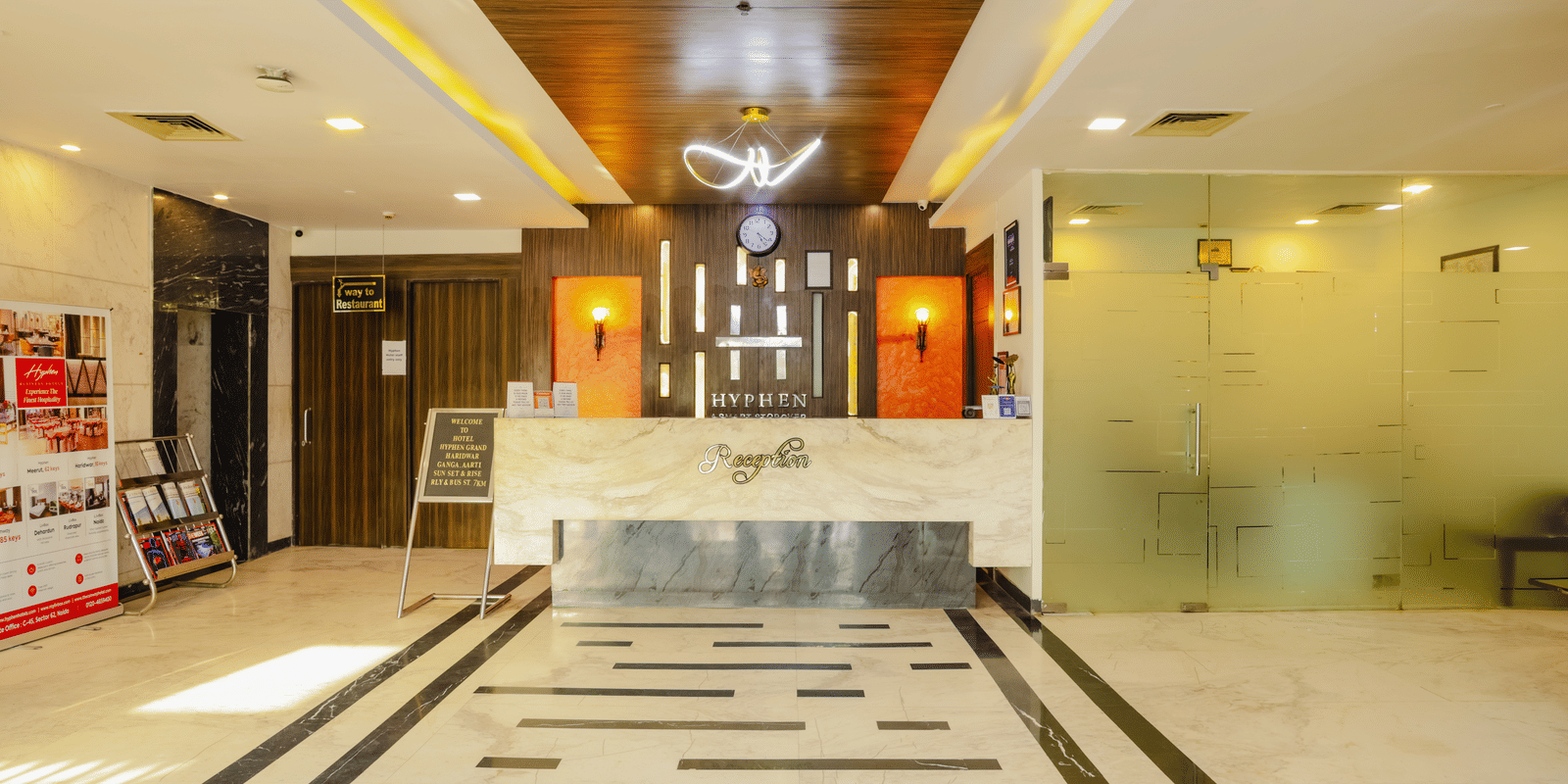 A hotel lobby or common area with a circular design feature and wooden doors - Hyphen Grand, Haridwar