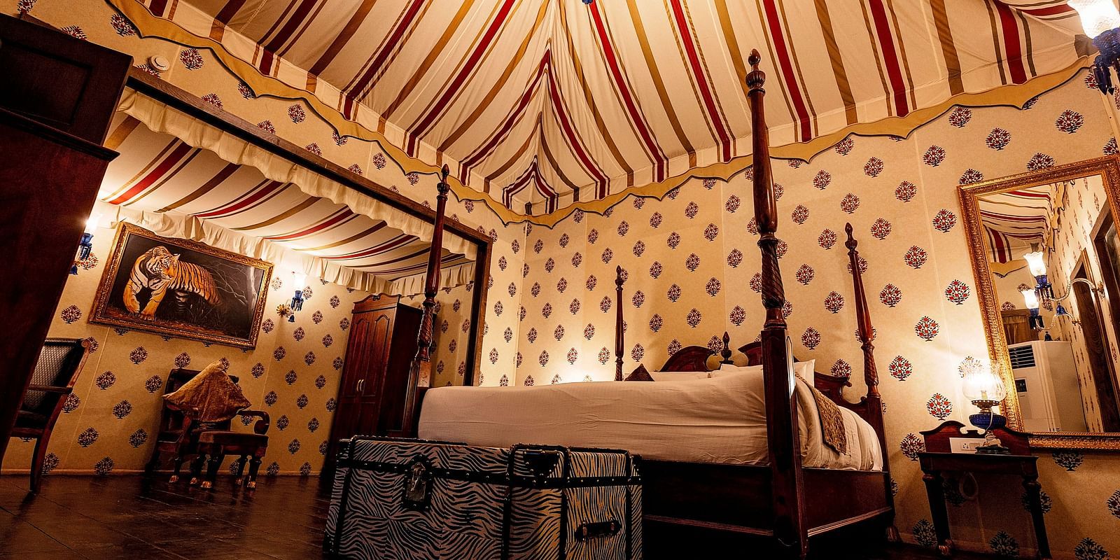 Image of a luxury tent with a bed and a mirror beside the bed Rajasthali Resort & Spa Jaipur.