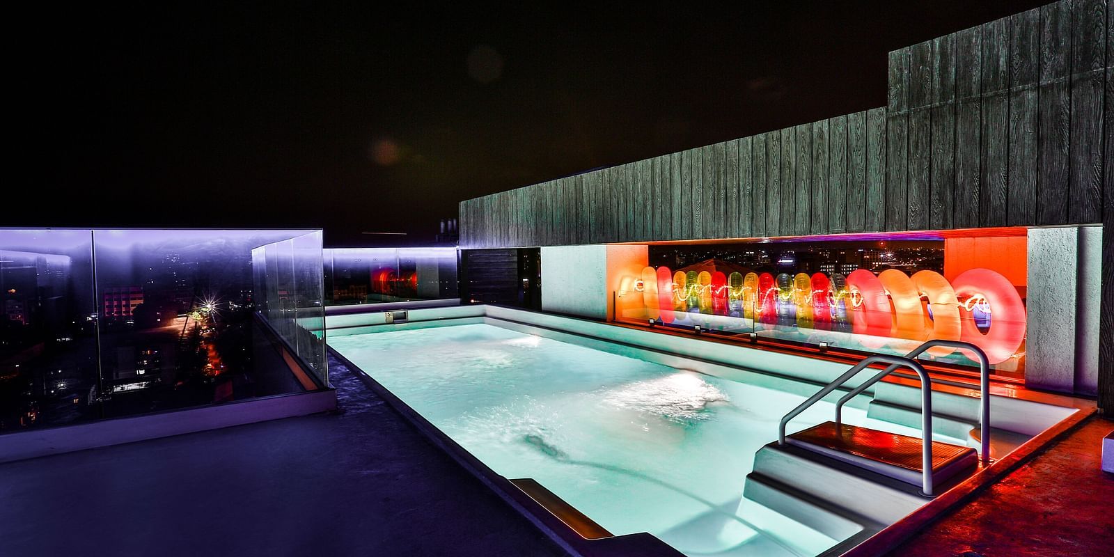 A well-lit rooftop swimming pool at T24 Residency, Andheri East, Mumbai at night