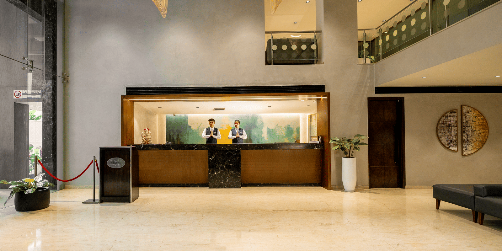 The reception and lobby area of the Citrine Hotel, featuring a large desk and a patterned floor.