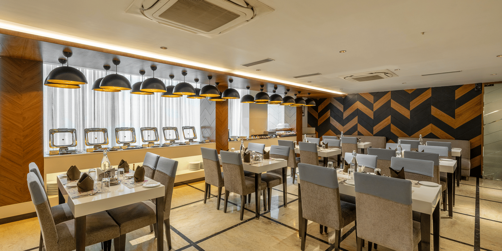 A wide view of the dining area in the Citrine Hotel, featuring neatly arranged tables and chairs.