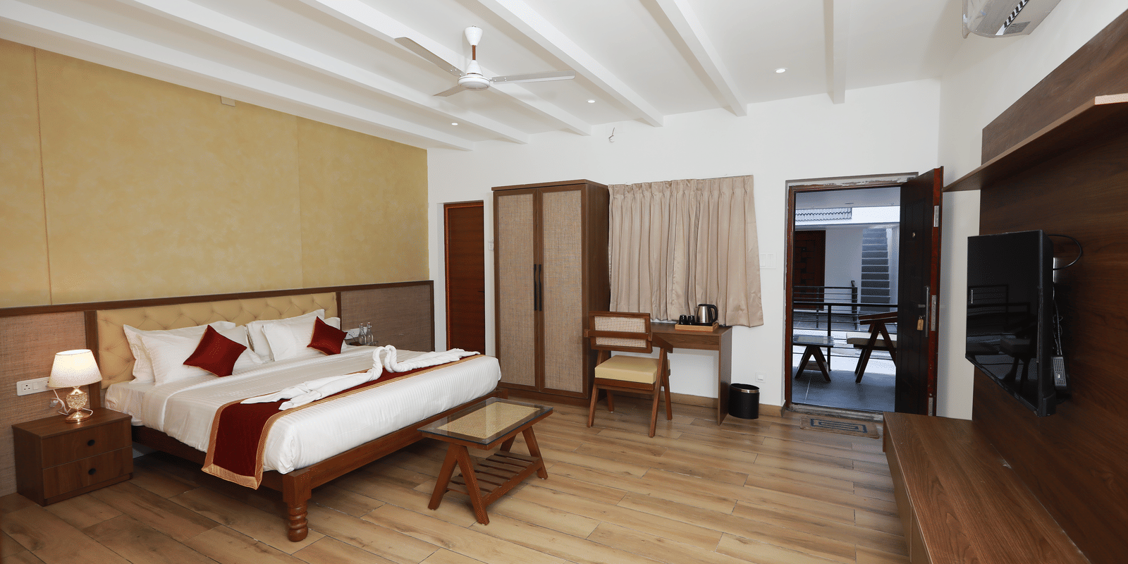 Full view of the Nature Luxury Room featuring wooden flooring along with a double bed in the middle of the room at WOW Naturefull Resorts, Yercaud.