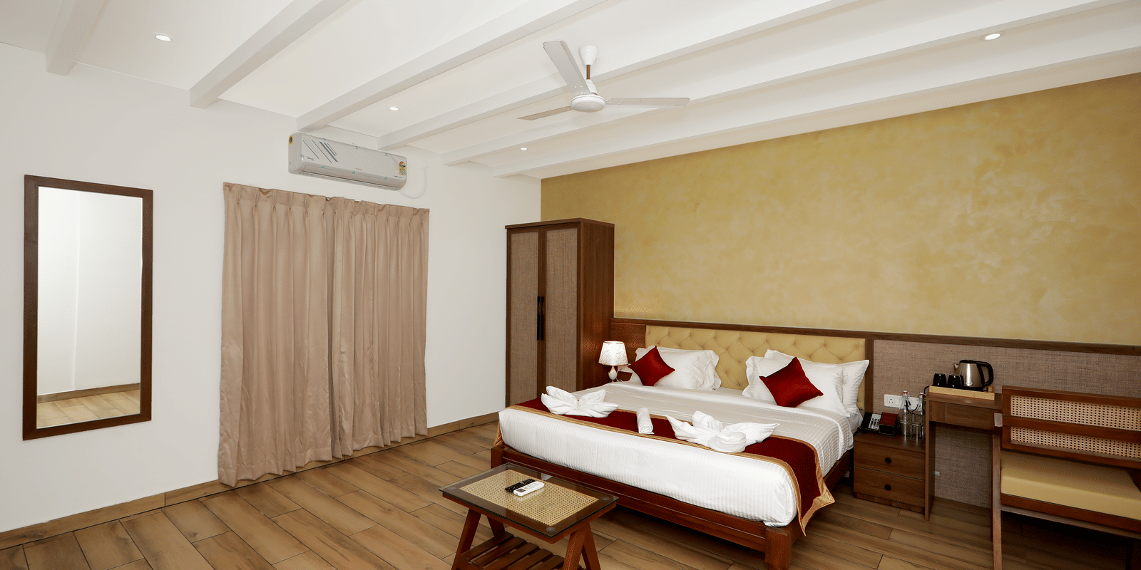 Full-view shot of the Terrace Cottage featuring a double bed, with a wall-mounted split AC above the window covered with beige-coloured curtains at WOW Naturefull Resorts, Yercaud.