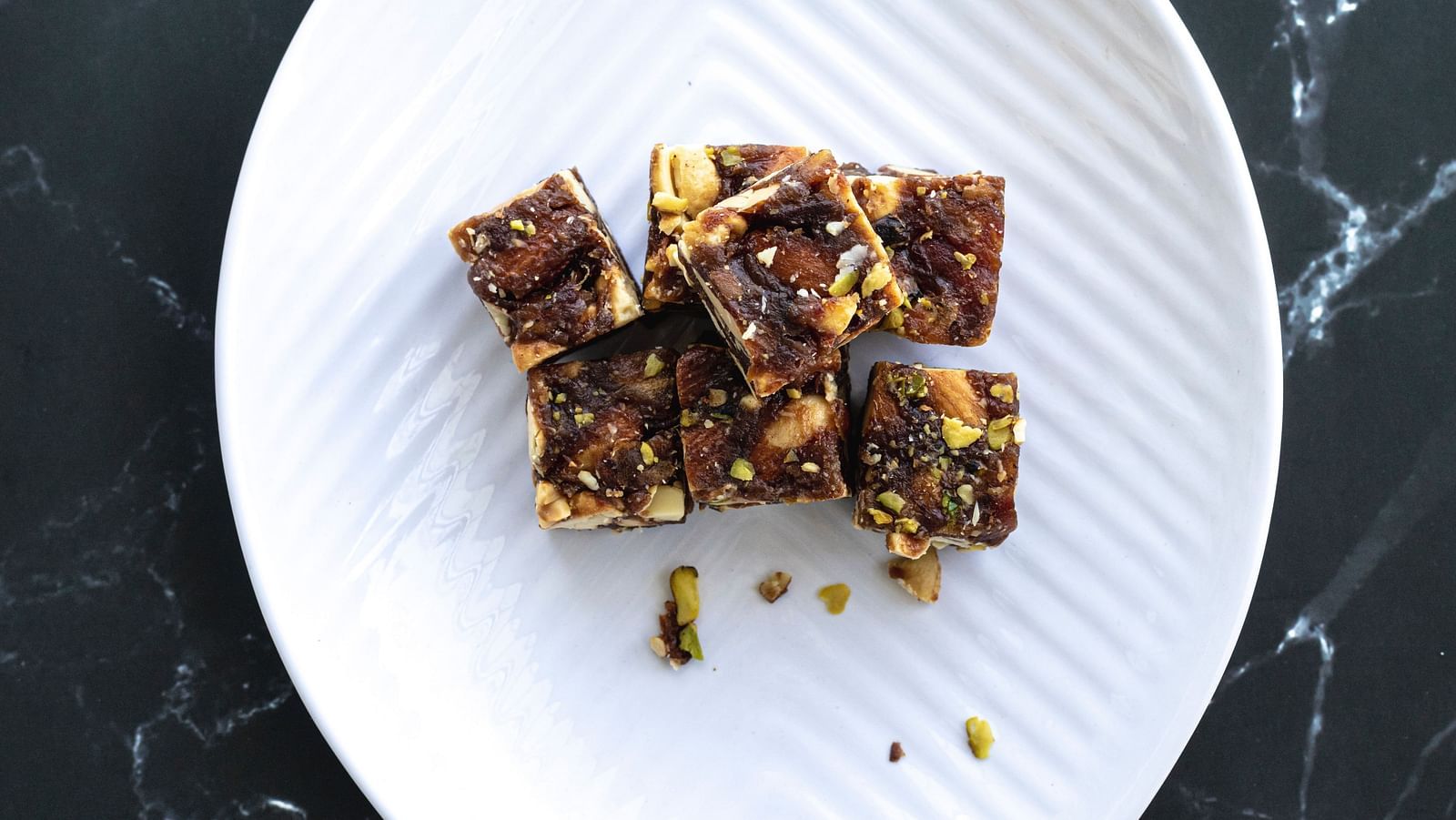an image of Chikki sweet displayed on a white plate as seen from above