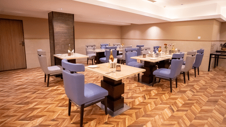 Nutmegg restaurant with neatly arranged tables and chairs at ASTER GRAND BY ZENQ SAKET.