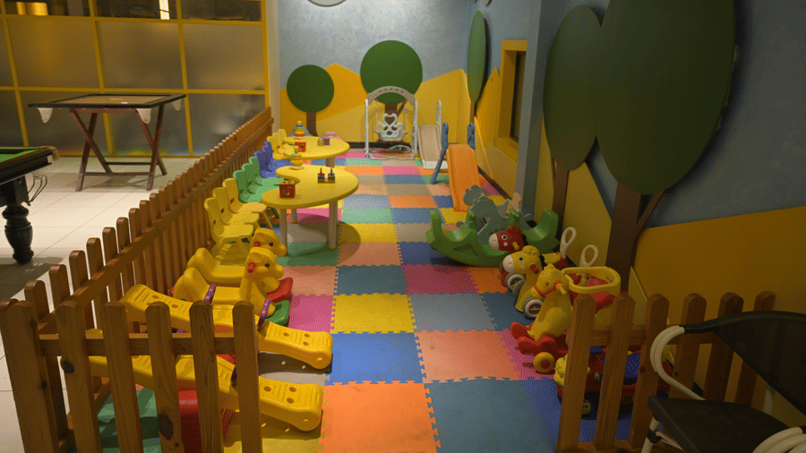 A colourful indoor children’s play area with soft mats and small seating at Hotel Sonar Bangla Mayapur.