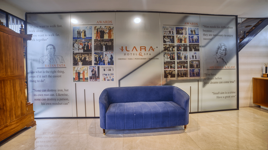 The spacious and well-lit hotel lobby featuring comfortable blue sofas, showcasing the contemporary interior design at Ilara Hotels & Spa, OMR, Chennai.