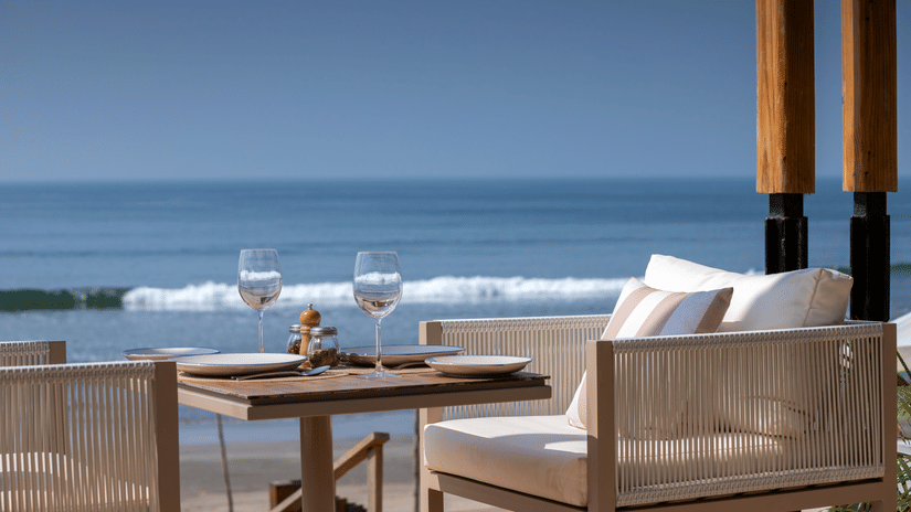 close up image of a chair with white cushion with a serene background of blue ocean
