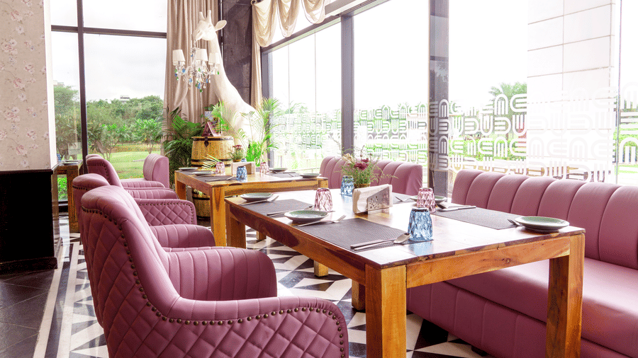 Seating arrangements inside On Kourse at Karma Lakelands with floor to ceiling windows.