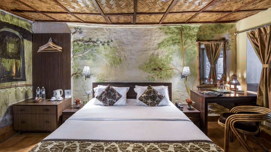 A nature-inspired room at Waxpol Hotels & Resorts with comfortable bed, mural walls, and modern amenities, offering a relaxing stay.