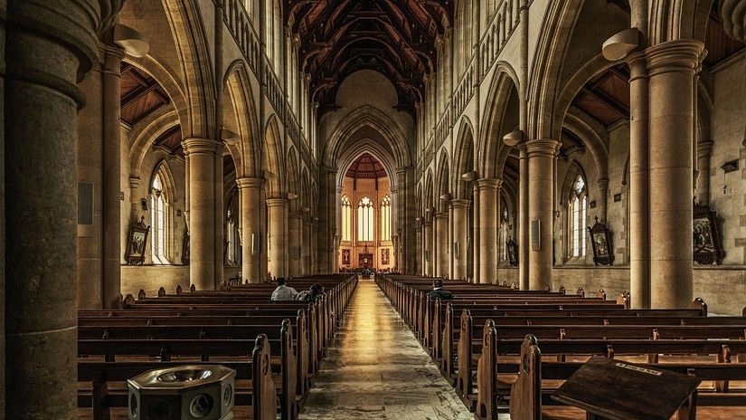 Interiors of a church with arches on the sides and pathway leading to the diaz