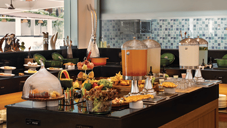 Buffet spread with fresh dishes and beverages arranged on a dining counter.