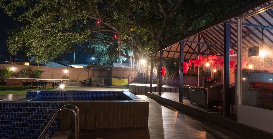 The pool and poolside area pictured at night - Wedlock Greens Hotel Resorts Dhanbad