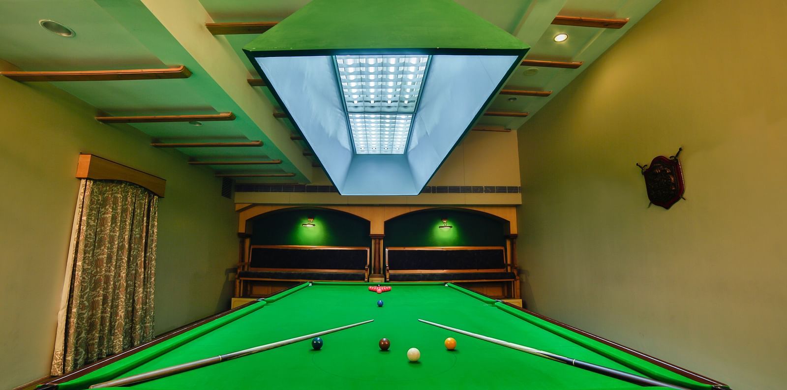 Pool table with billiards cue sticks placed at the corners at Tara, Comfort Hotel in Hyderabad - Ramoji Film City.