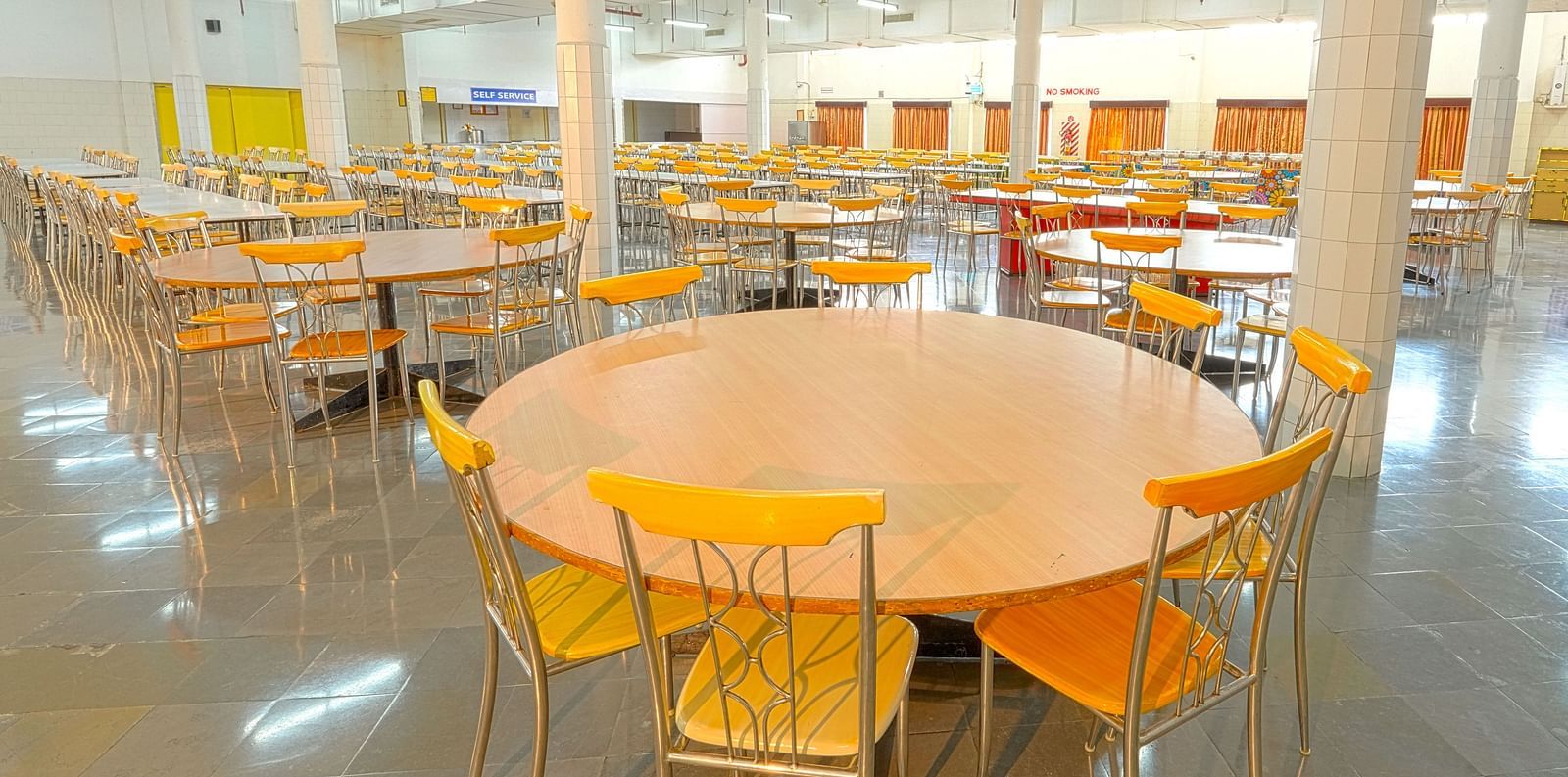 A colourful cafeteria with round tables at Sahara - Cozy Dining in Hyderabad.