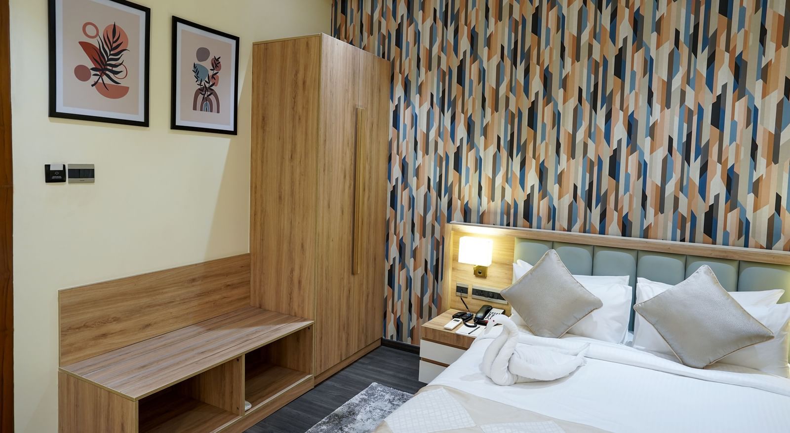 A wooden wardrobe along with a luggage rack placed in the corner beside a double bed in the Deluxe Room at M2 Square by Monday Premium.