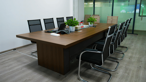 A boardroom set up with a wooden desk and chairs.
