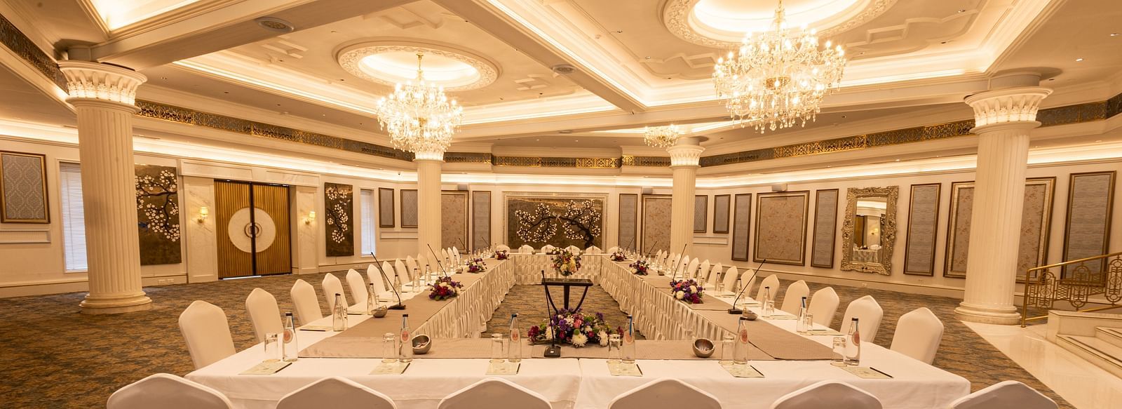 Image featuring the Viceroy Hall event venue at The Claridges New Delhi, showcasing seating arrangements and an elegant chandelier hanging overhead