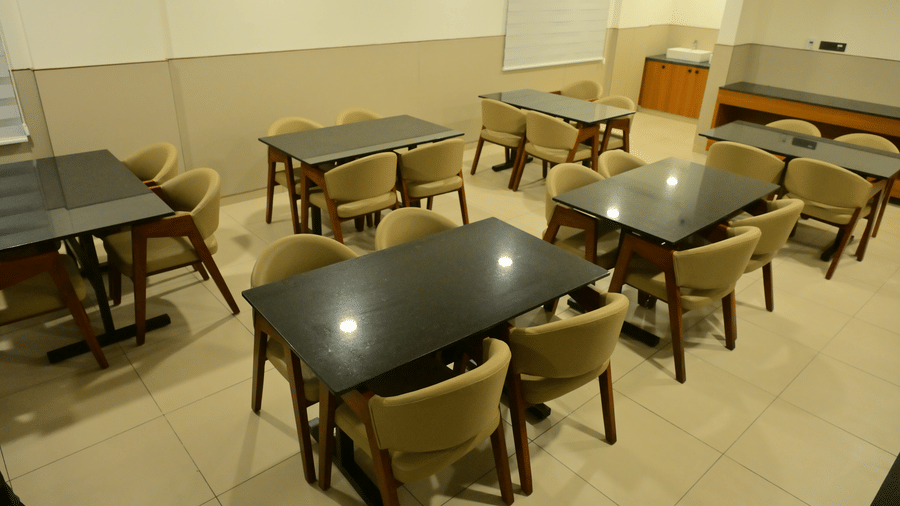 Casual dining area at Bhavanis Vista By Icon Hosur with neatly arranged tables and chairs in a well-lit space.