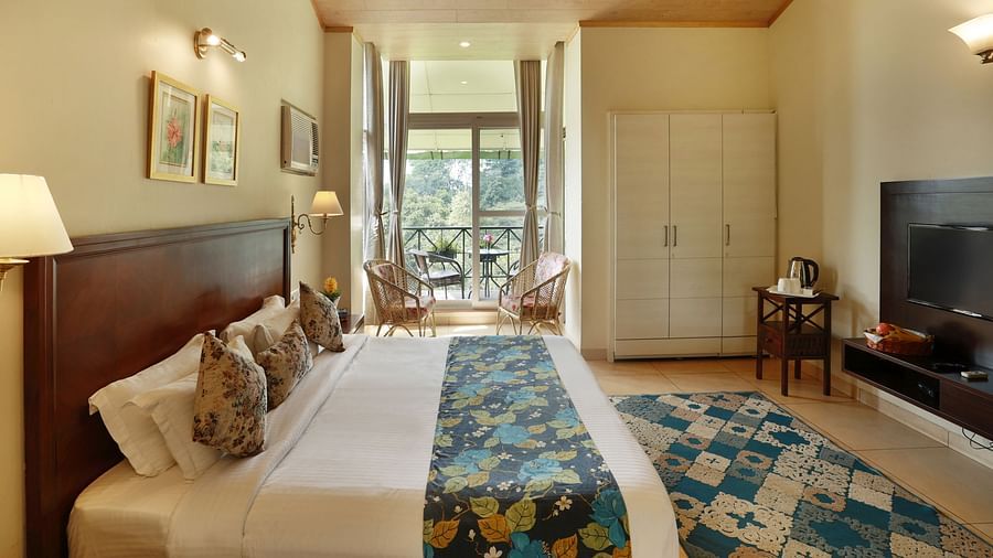 Full angle view of Super deluxe room featuring a balcony overlooking the tea gardens and other room amenities like a television, a tea & coffee maker, among others - Lamrin Norwood Green, Palampur2