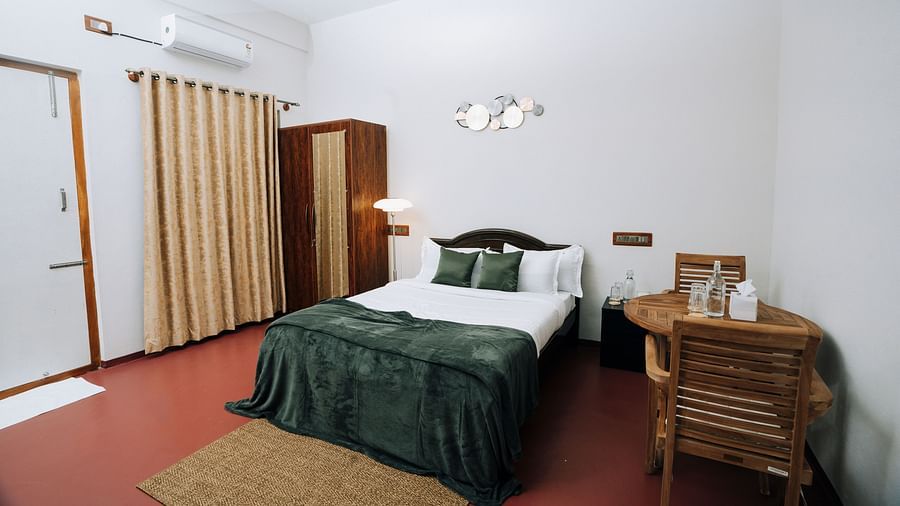 A bed, wardrobe, and work desk in a  room | Habba Dates Villa, Hampasandra