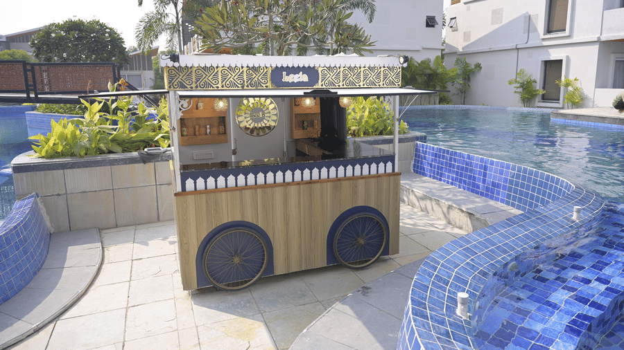 A charming poolside refreshment cart set beside the blue-tiled pool area at Hotel Sonar Bangla Mayapur.