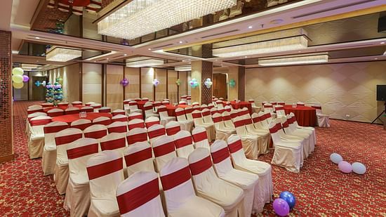 Blossom Hall with stylish decor, lights, and chairs at Icon Premier Hotel by Bhagini, Devarabisanahalli
