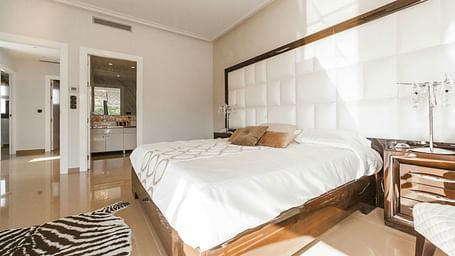 Image of a room with bed, bedside table and a rug by the feet of the bed | Faraway Cottages, Auli