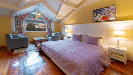 A cosy attic bedroom with a large window offering a view of the Manali mountains - Johnson Lodge & Spa, Manali