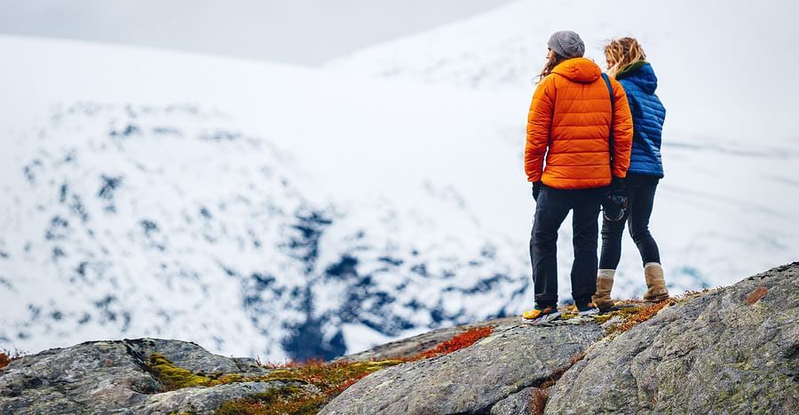 Couple standing on a snow clad cliff 2