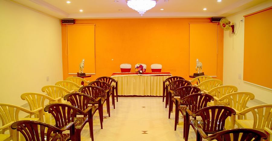 alt-text  Hall Hotel Yasodha Towers - Interior view of the conference room featuring 4 columns of chairs placed on either sides of the room