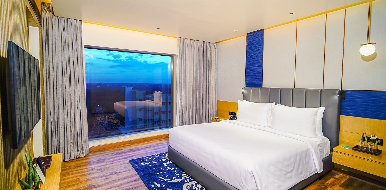 An image of our Junior Suite in Madurai with a beautiful sunset view from the window - Grand Madurai by GRT Hotels
