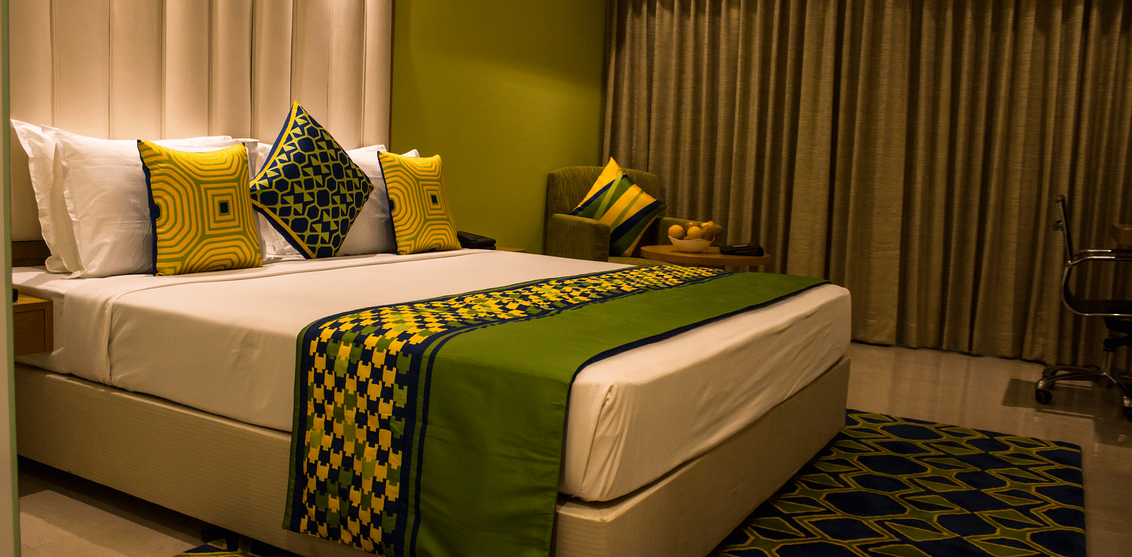 Image of a room with a bed and  pillows arranged on it  along with  a balcony | Regency Tirunelveli By GRT Hotels