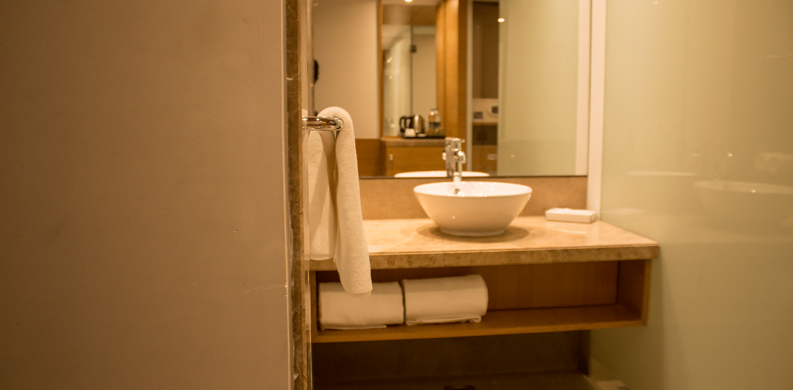 Image of an bathroom with a sink, mirrors  and towels | Regency Tirunelveli By GRT Hotels
