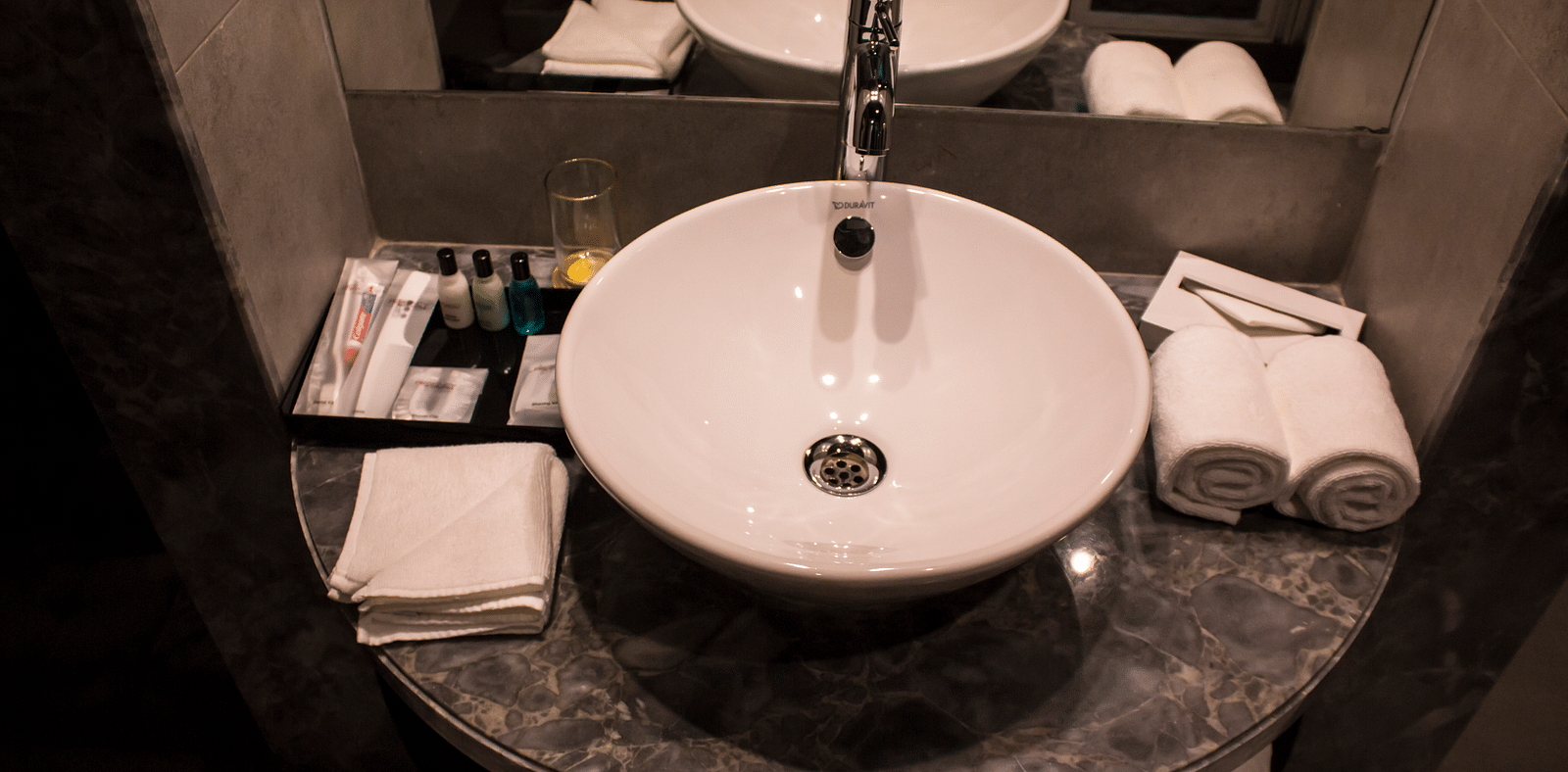 Image of a bathroom with a sink, mirrors  and towels | Regency Tirunelveli By GRT Hotels