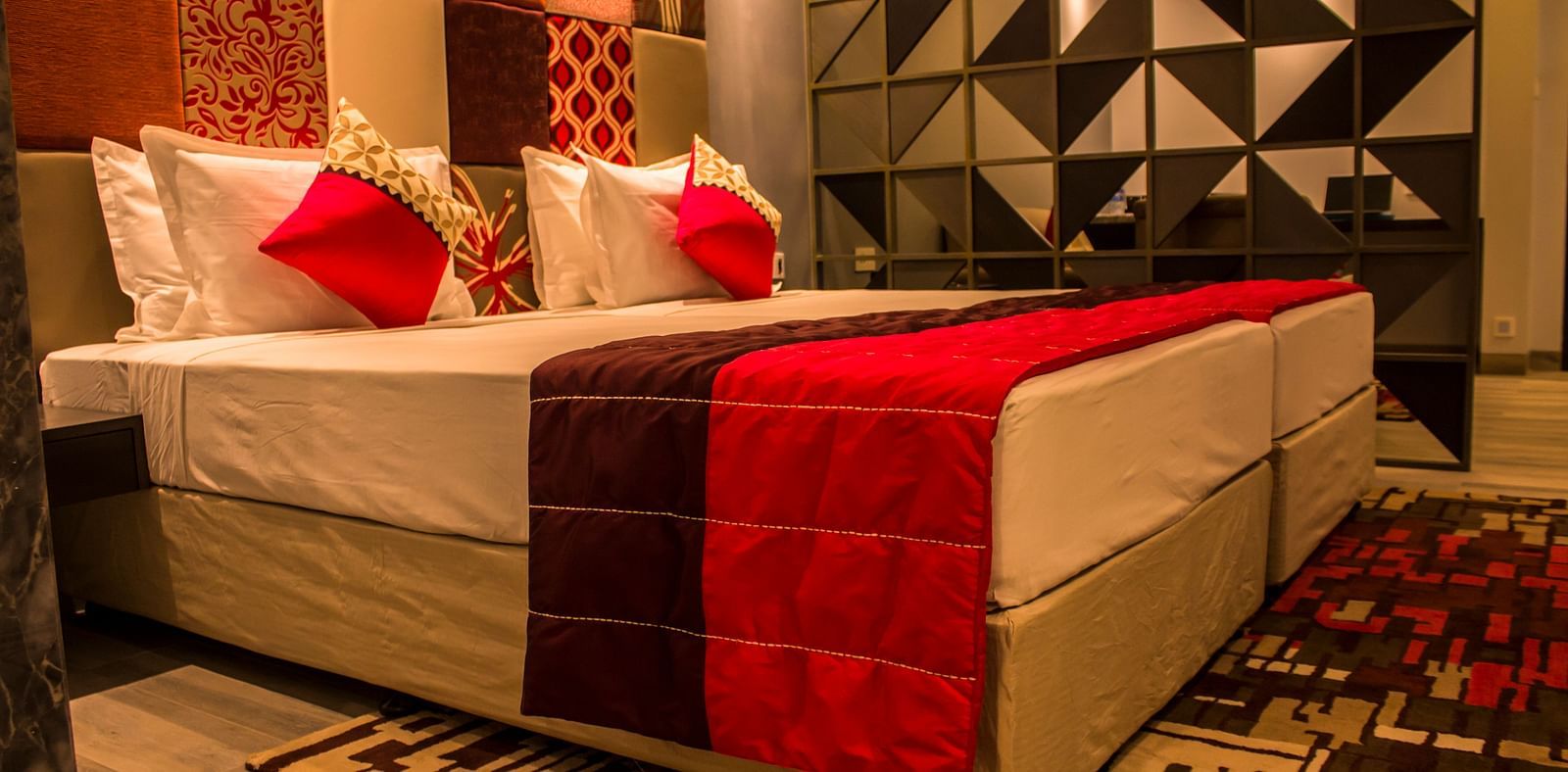 lower angle image of a room with twin beds and  pillows arranged on it  | Regency Tirunelveli By GRT Hotels