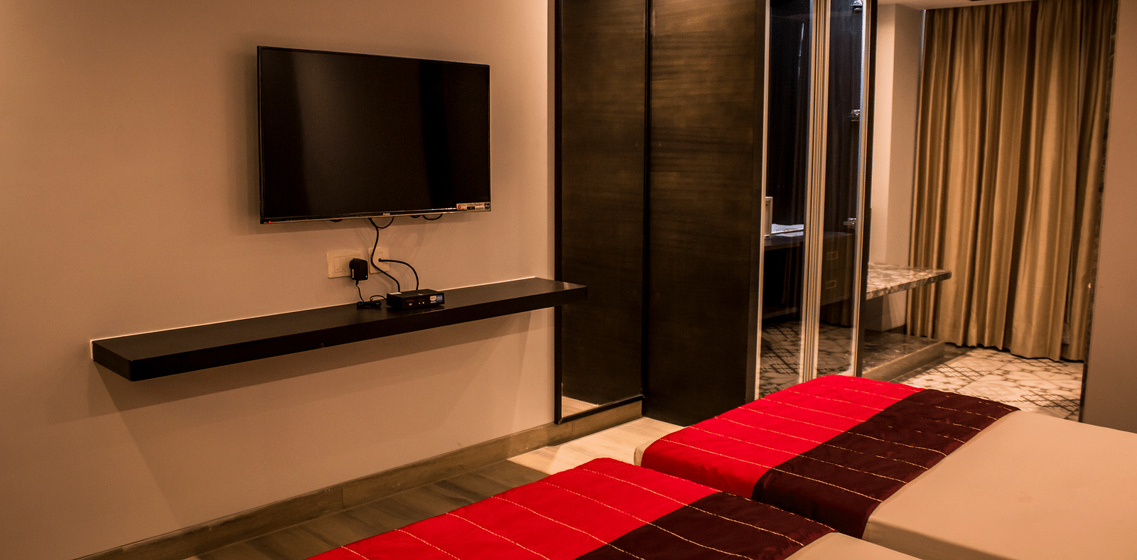 Side view of a room with twin beds and  pillows arranged on it  | Regency Tirunelveli By GRT Hotels