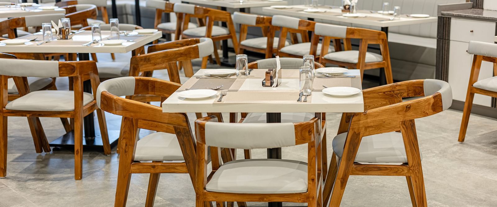 Wooden seating and sleek arrangement in the restaurant at Lemonridge Hotels, IDPL Balanagar