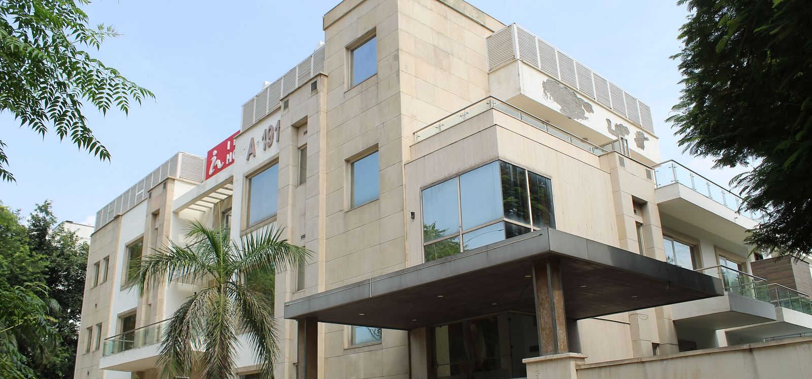A facade image of Inde Hotels Vista Woods featuring a multi storey building surrounded by trees