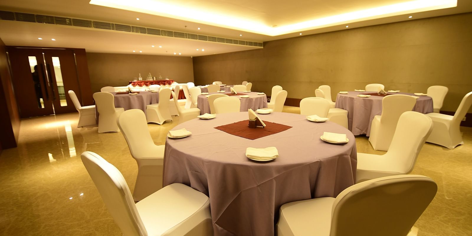 A spacious event space featuring round tables and chairs arranged, perfectly set up for any celebration