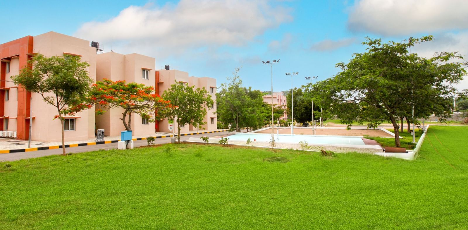 Panoramic view of Greens Inn with a lawn in front of it - Spacious Hotel Grounds in Hyderabad.