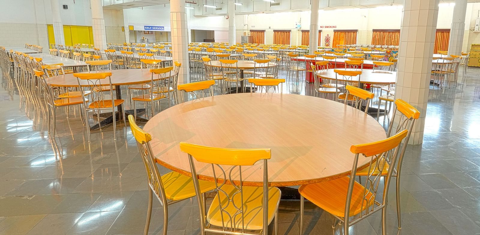 A colourful cafeteria with round tables at Sahara - Cozy Dining in Hyderabad.